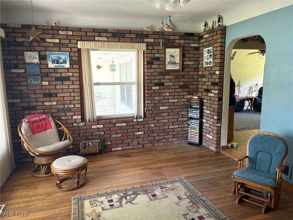 3181 Jaycox Road Avon, OH 44011 - Photo 24 of 48 Living area featuring wood finished floors, ceiling fan, arched walkways, a textured ceiling, and brick wall
