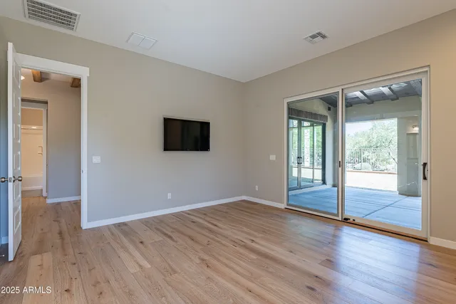 a large kitchen with a center island wooden floor and stainless steel appliances