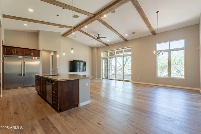 a kitchen with granite countertop a sink a counter space and stainless steel appliances