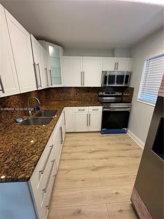 a kitchen with stainless steel appliances granite countertop a stove and a sink