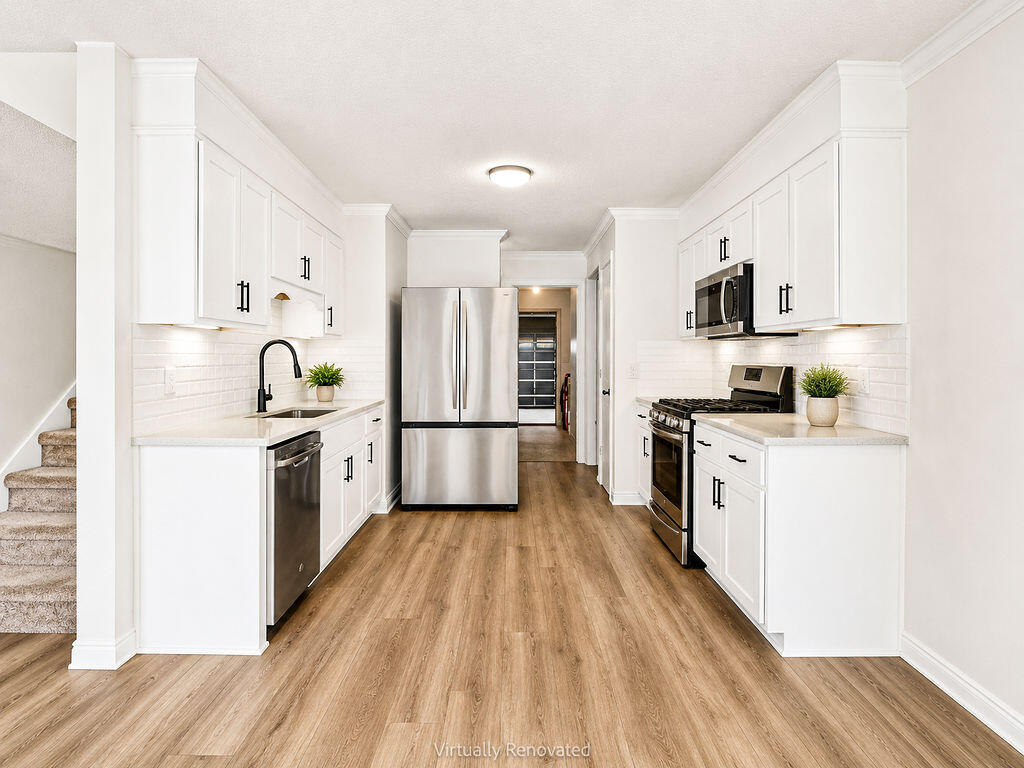 53 4th Street Shalimar, FL 32579 - Photo 12 of 47 a kitchen with white cabinets a sink and wooden floor
