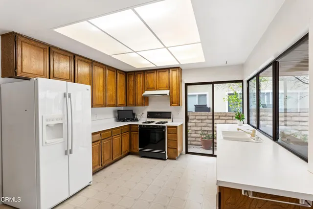 a kitchen with stainless steel appliances a refrigerator sink and stove