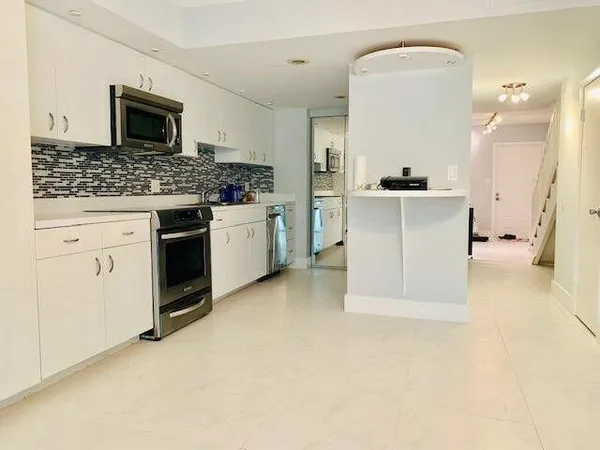 a view of kitchen with granite countertop cabinets and white appliances
