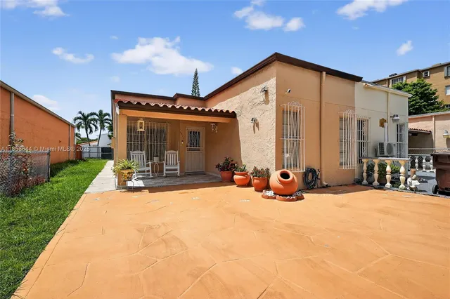 a view of a porch with a table and chairs and potted plants