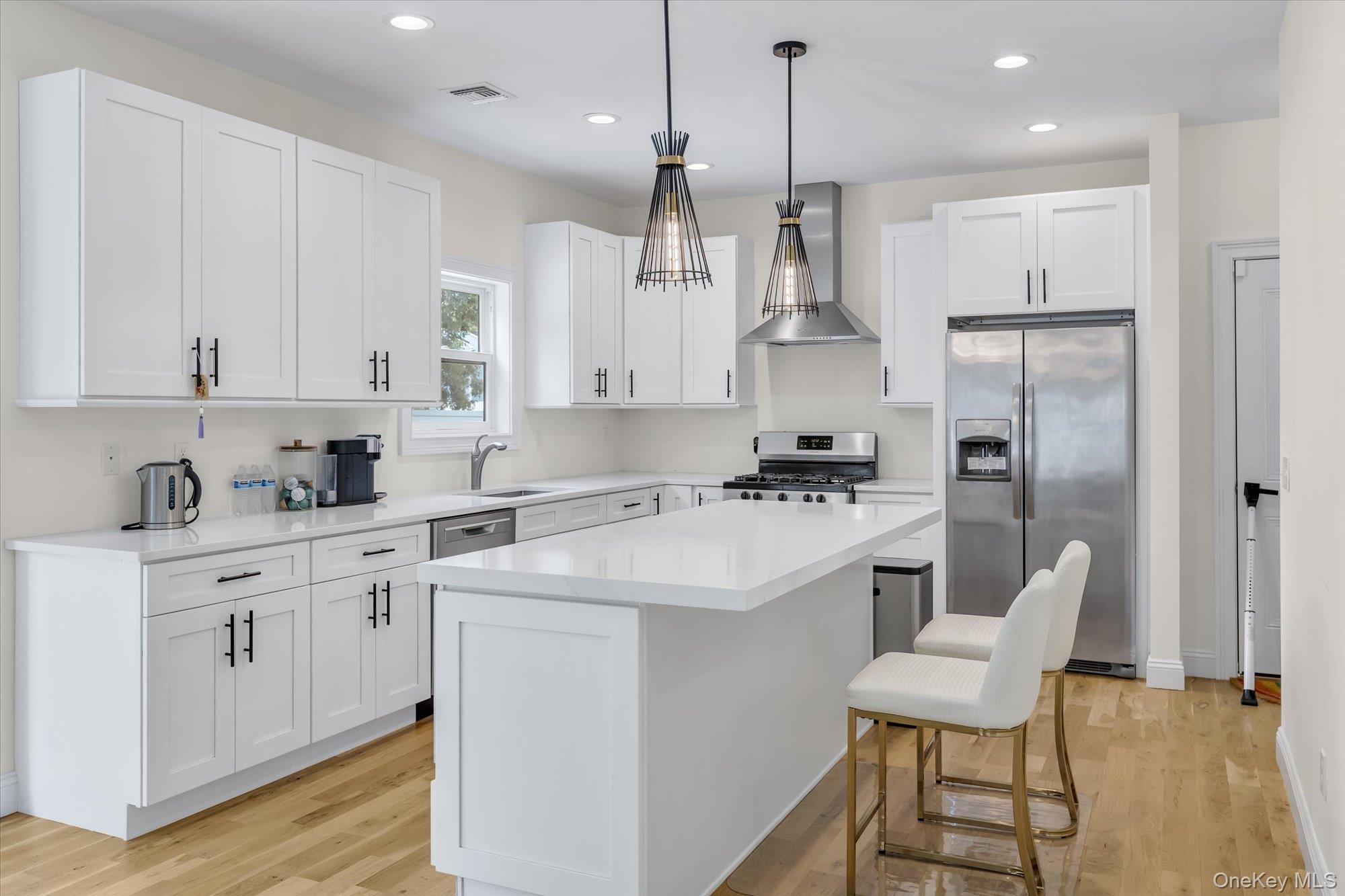 135 Elizabeth Way Ridge, NY 11961 - Photo 8 of 24 a kitchen with white cabinets and stainless steel appliances