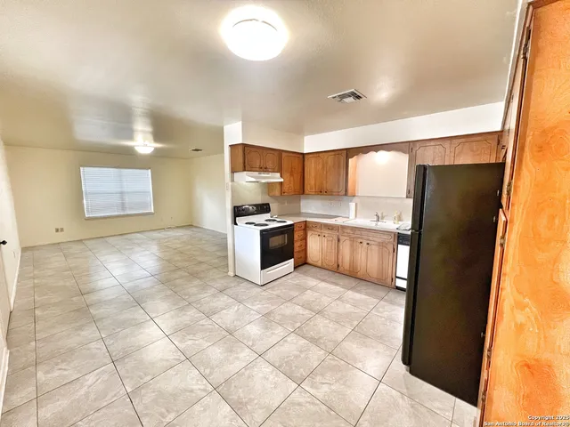a kitchen with stainless steel appliances a refrigerator and a counter top space