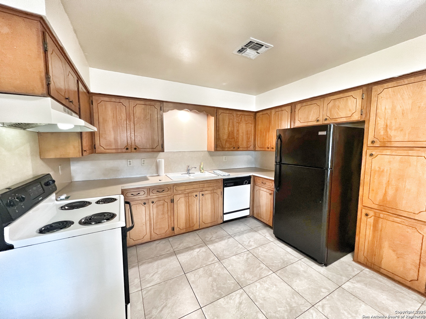 343 Bobolink Drive New Braunfels, TX 78130 - Photo 9 of 18 a kitchen with a refrigerator a stove top oven a sink and dishwasher
