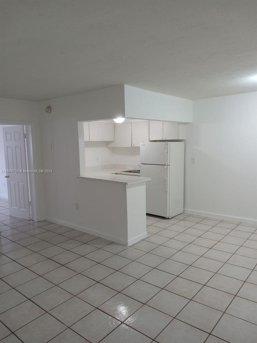 1230 West 54th Street, Unit 216A Hialeah, FL 33012 - Photo 7 of 28 a kitchen with a sink cabinets and appliances