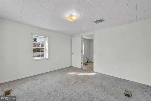 an empty room with a window and fireplace