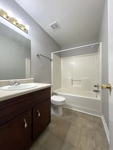 a bathroom with a double vanity sink toilet mirror and bathtub