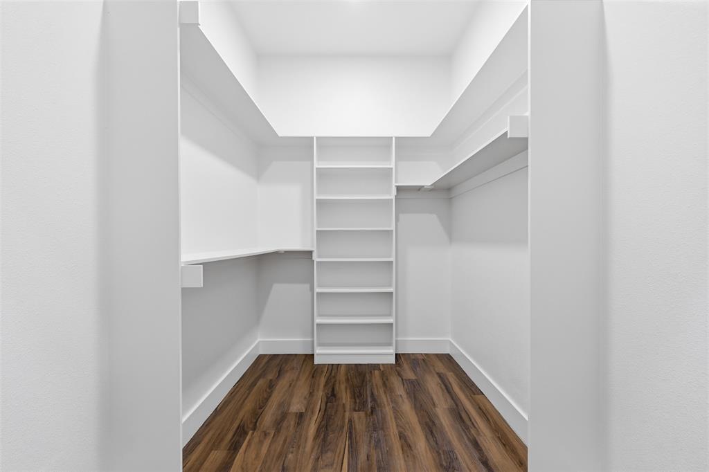 1413 Ridgeview Circle Granbury, TX 76048 - Photo 17 of 35 Walk-in closet featuring white built-in shelving, white walls, white baseboards, and wood-finish flooring