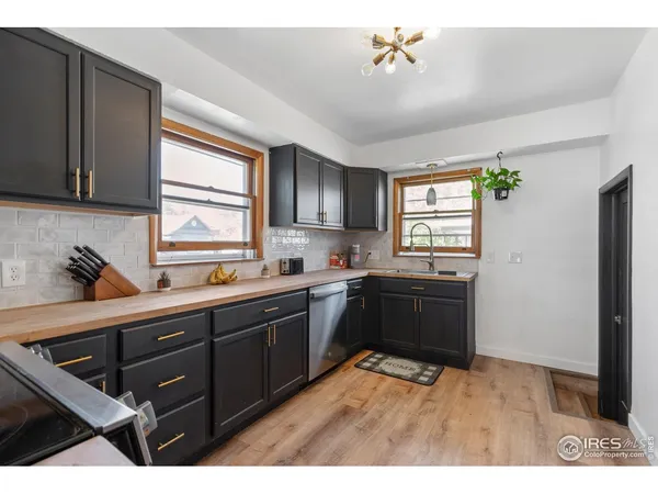 a kitchen with granite countertop a refrigerator and cabinets