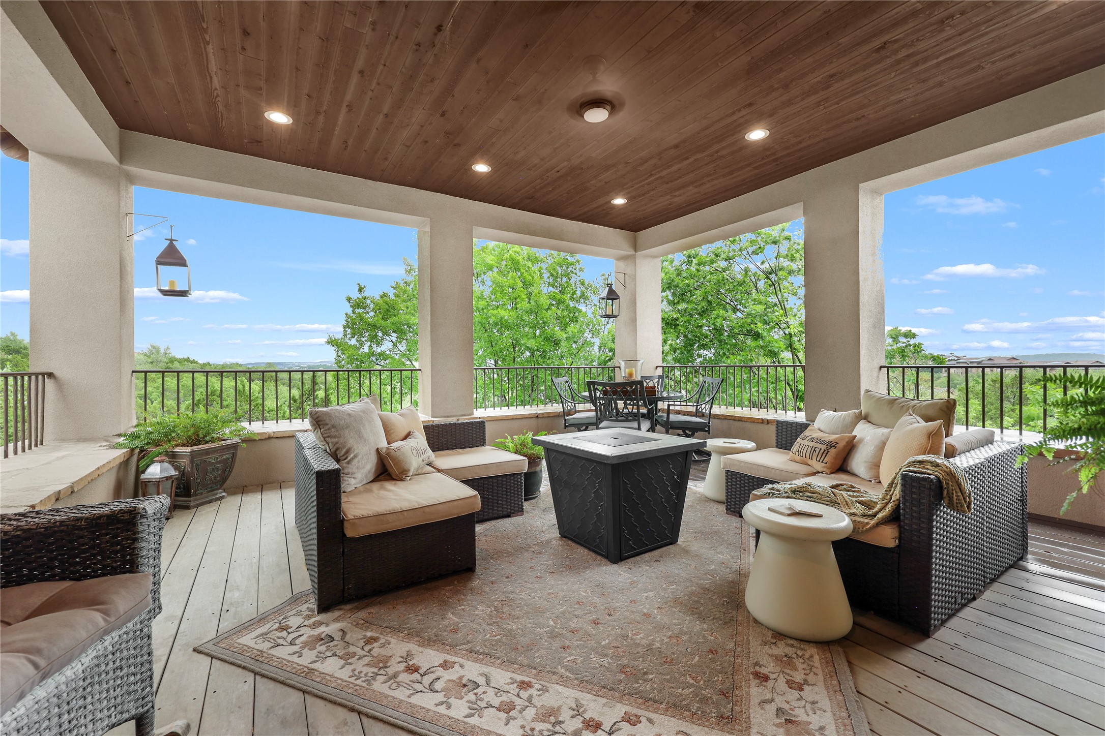 17501 Navigation Lane Lago Vista, TX 78645 - Photo 34 of 40 Expansive upstairs covered outdoor living space featuring a wood-planked ceiling with recessed lighting, a decorative railing, and views of the surrounding trees and sky