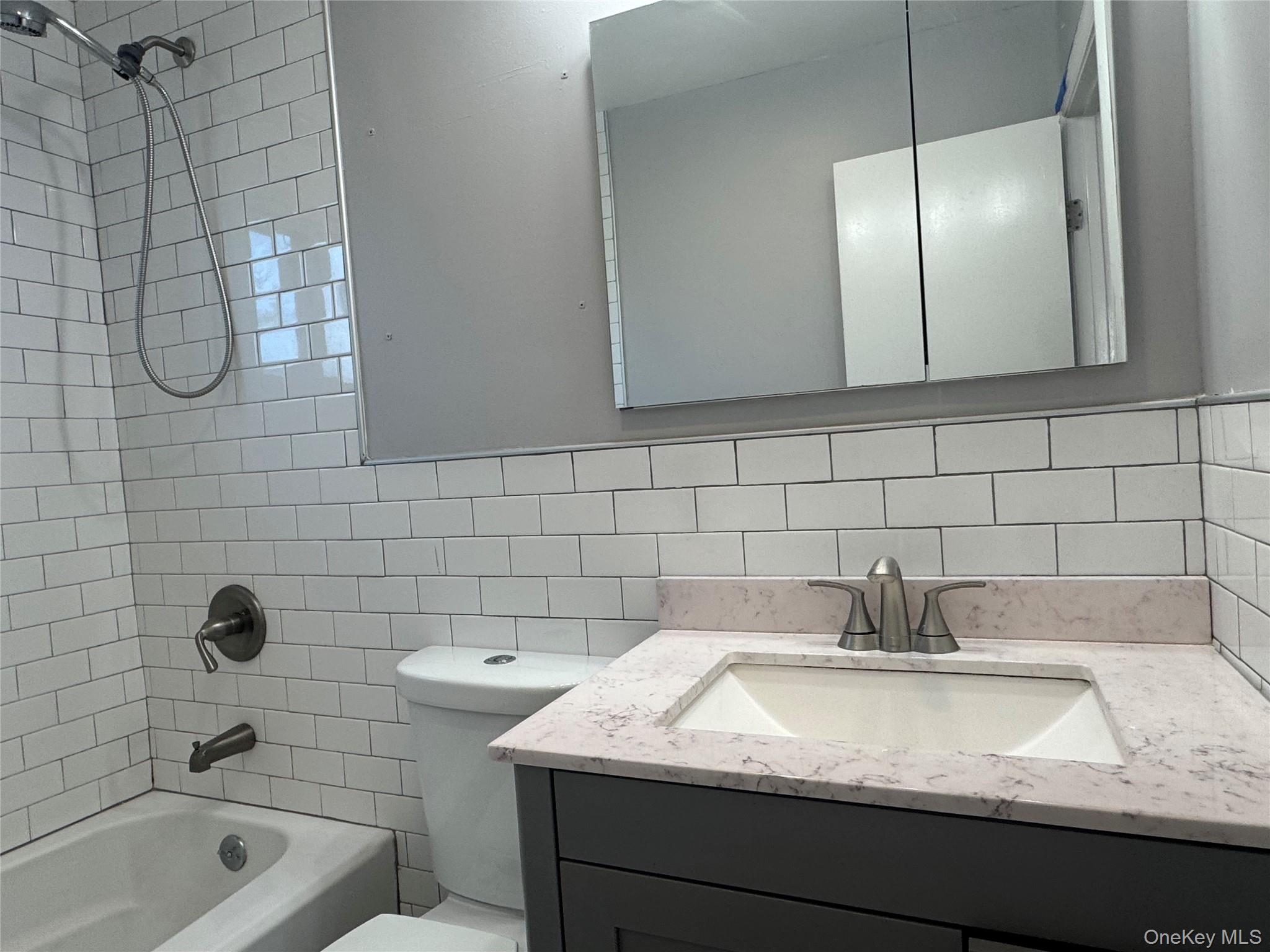 1239 August Road North Babylon, NY 11703 - Photo 15 of 16 a bathroom with a granite countertop sink a toilet and shower