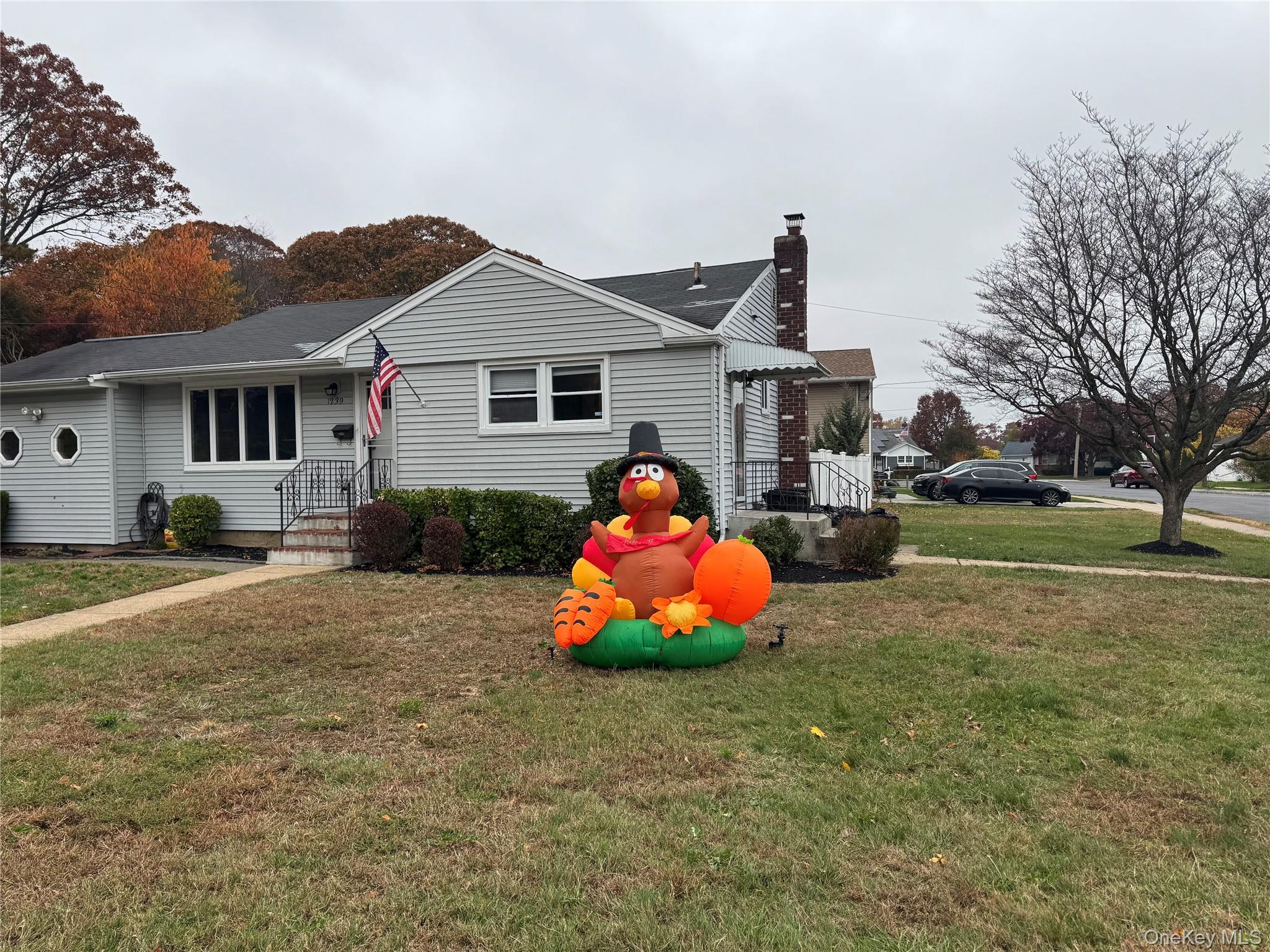 1239 August Road North Babylon, NY 11703 - Photo 2 of 16 a front view of house with yard and trees around