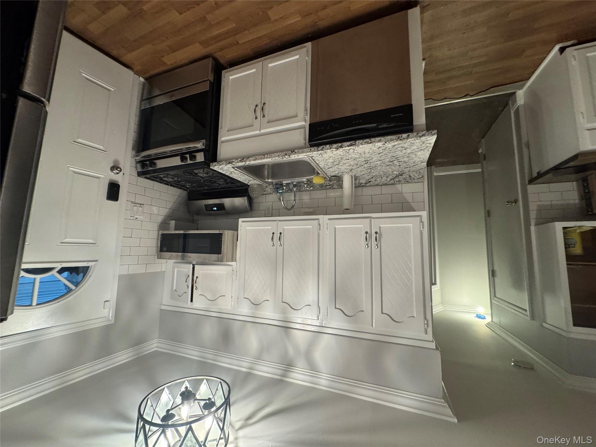 1239 August Road North Babylon, NY 11703 - Photo 3 of 16 a kitchen with stainless steel appliances granite countertop a stove a refrigerator and a sink with wooden floor