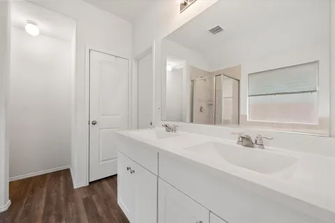 a bathroom with a double vanity sink and mirror