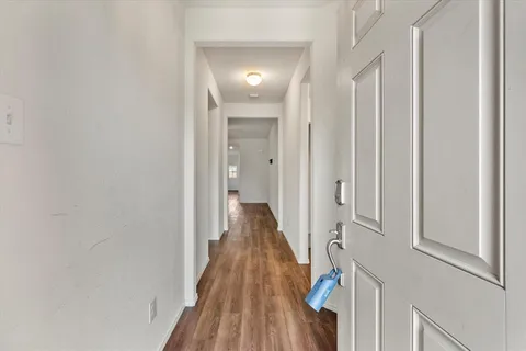 a view of a hallway with wooden floor and staircase