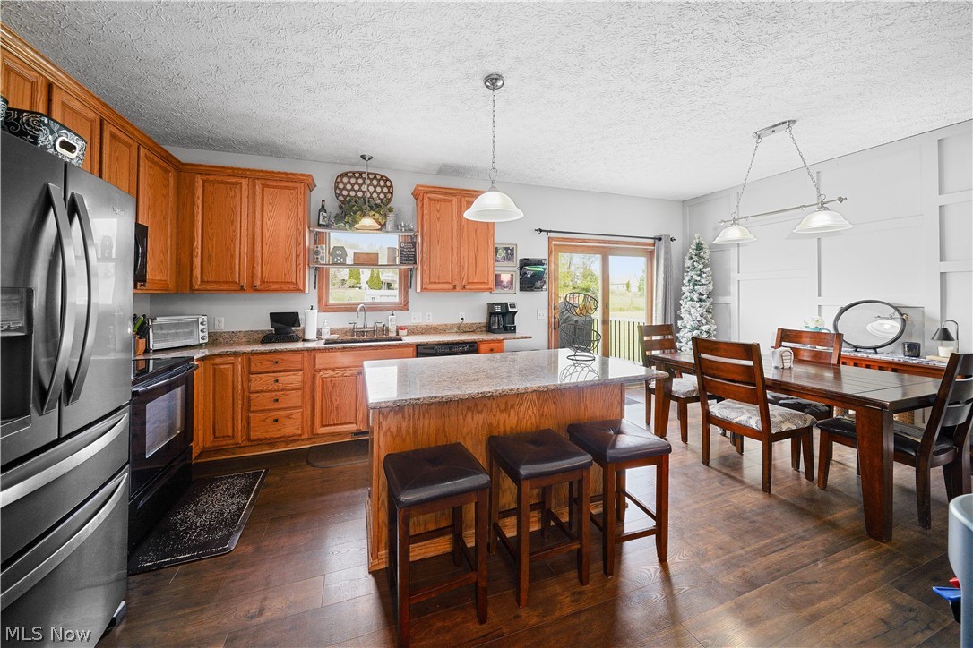 4849 Edson Road Kent, OH 44240 - Photo 16 of 50 Kitchen featuring a kitchen island, dark hardwood / wood-style floors, stainless steel fridge with ice dispenser, and stove