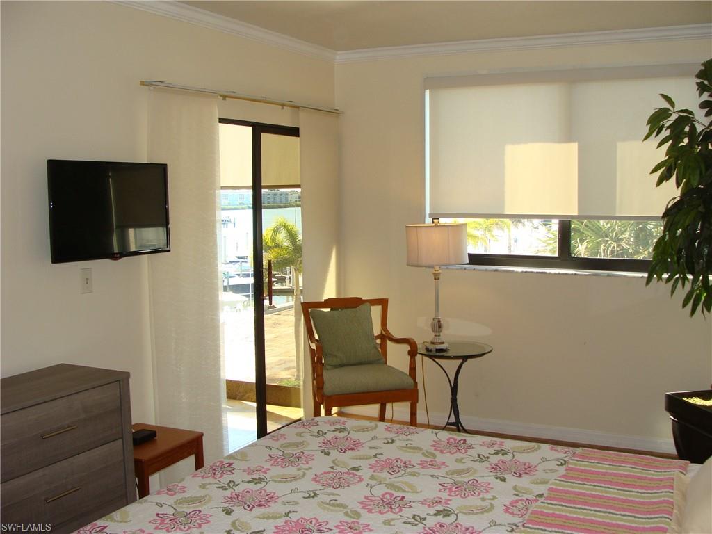807 River Point Drive, Unit 201D Naples, FL 34102 - Photo 12 of 31 a bedroom with furniture and a window