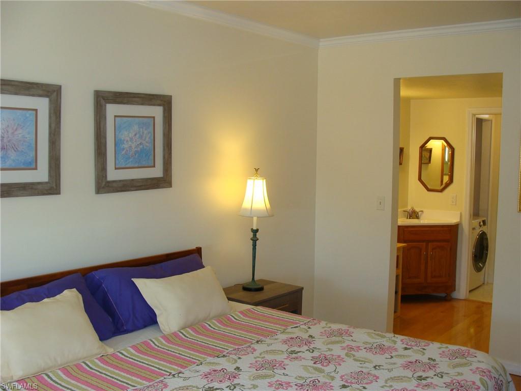 807 River Point Drive, Unit 201D Naples, FL 34102 - Photo 13 of 31 a bedroom with a bed and a table