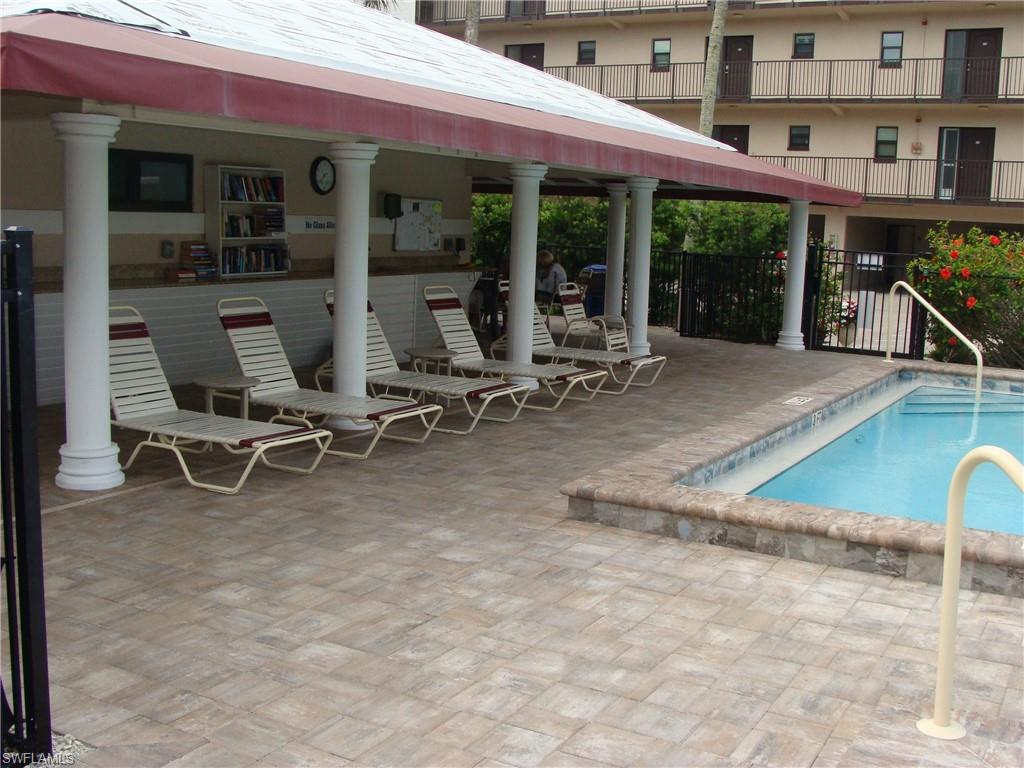 807 River Point Drive, Unit 201D Naples, FL 34102 - Photo 23 of 31 a view of a patio with table and chairs near a floor to ceiling window