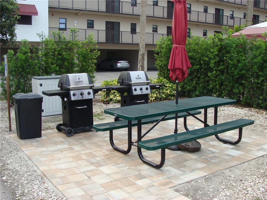 807 River Point Drive, Unit 201D Naples, FL 34102 - Photo 24 of 31 a view of a chairs and tables in the back yard of a building