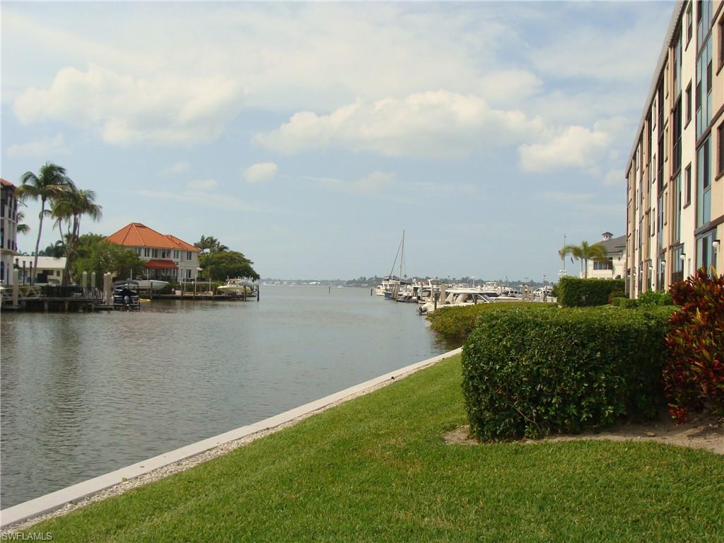 807 River Point Drive, Unit 201D Naples, FL 34102 - Photo 25 of 31 a view of a lake with lawn chairs
