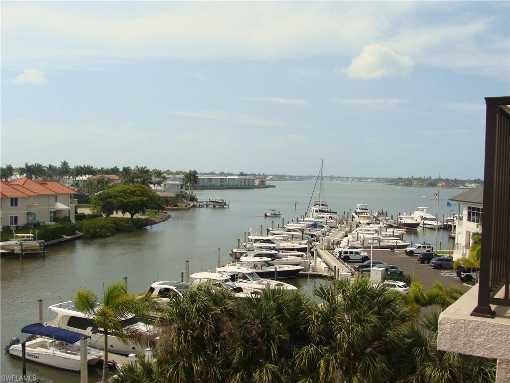 807 River Point Drive, Unit 201D Naples, FL 34102 - Photo 30 of 31 a view of a lake with boats and trees in the background