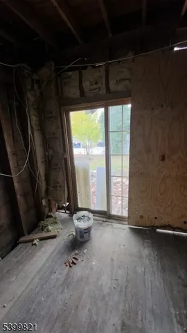 a view of a room with wooden floor and a floor to ceiling window