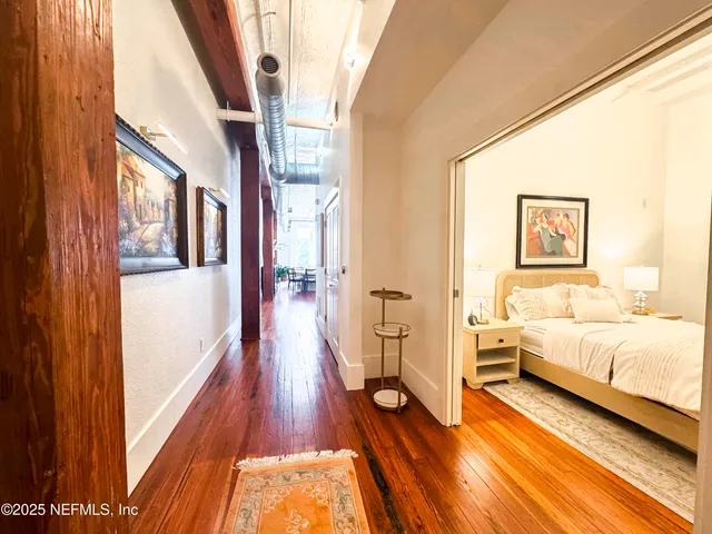 a view of a bedroom with wooden floor and furniture