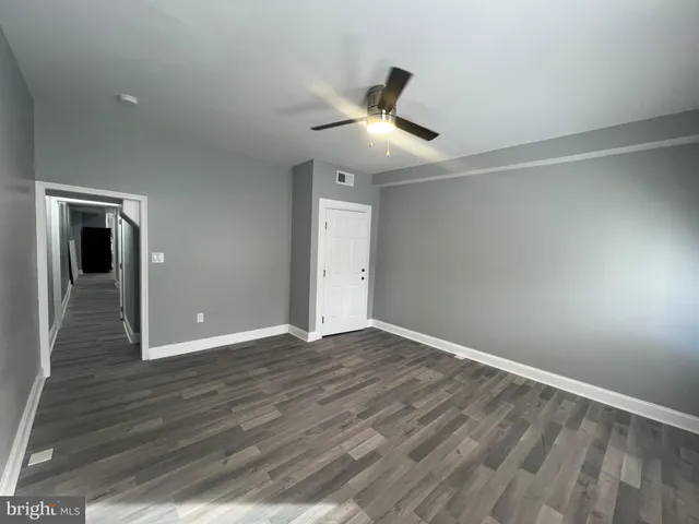 a view of an empty room with wooden floor