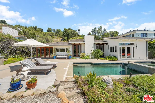 a view of a house with swimming pool and furniture