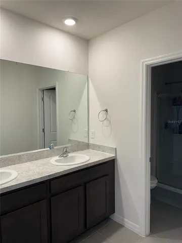a bathroom with a double vanity sink and a mirror