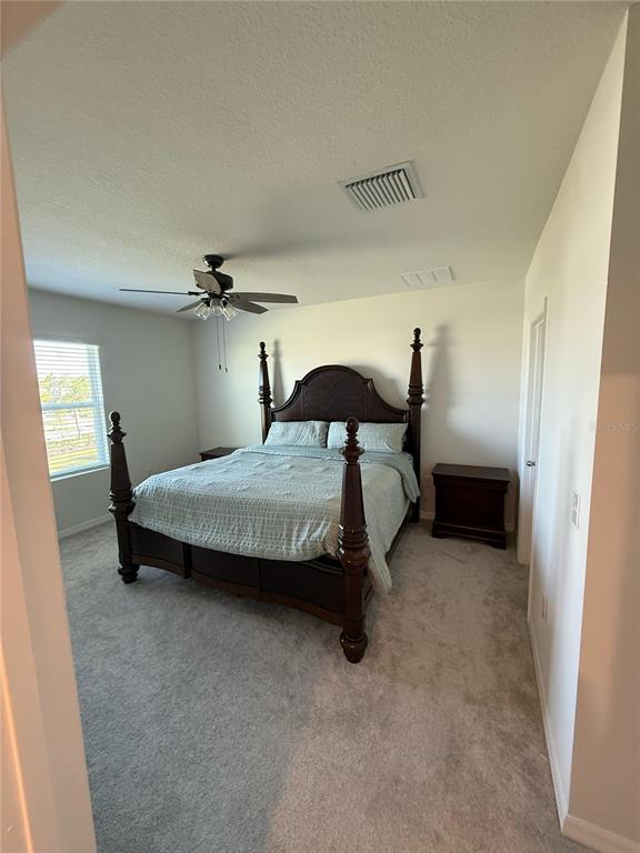 16177 Glowing Grove Avenue Odessa, FL 33556 - Photo 8 of 13 a bedroom with a bed and a table