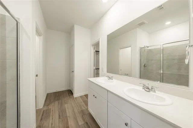 a bathroom with a double vanity sink and mirror with shower