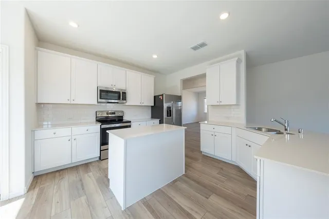 a kitchen with granite countertop white cabinets and white appliances