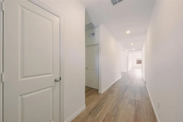 a view of a hallway with wooden floor