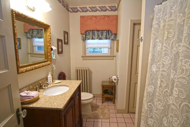 a bedroom with a bed and large windows