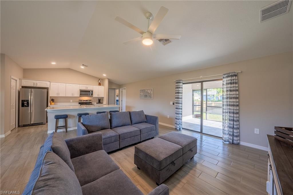 8152 Pelican Road Fort Myers, FL 33967 - Photo 6 of 24 Open-concept living space featuring wood-finish flooring, a vaulted ceiling, and a ceiling fan