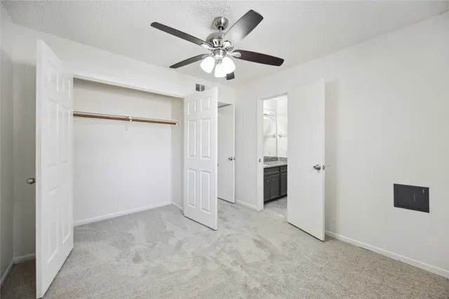 a view of an empty room with a ceiling fan