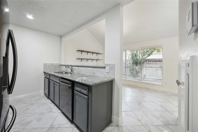 a kitchen with granite countertop a sink and a stove