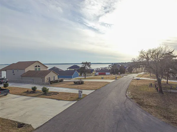 an aerial view of residential houses with yard and mountain view in back