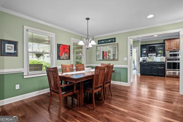 a living room with furniture a chandelier and a floor to ceiling window