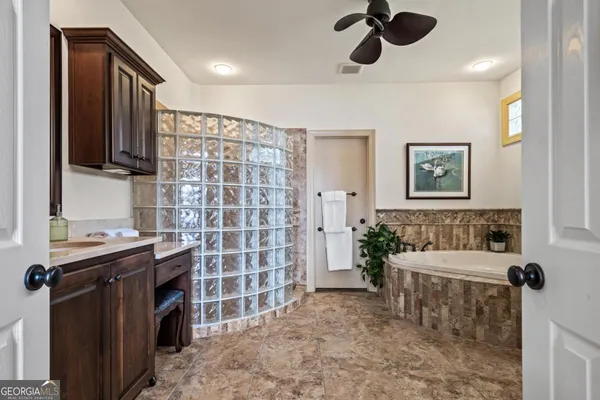 a bathroom with a granite countertop sink a toilet and a mirror