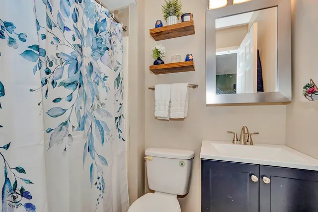 a bathroom with a sink toilet and a mirror