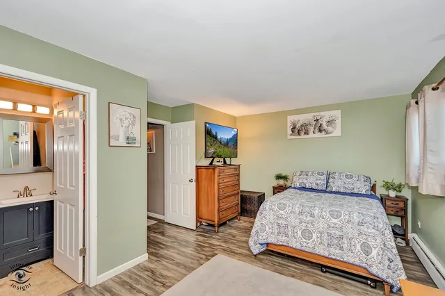 a bedroom with a bed and dresser with mirror