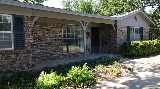a front view of a house with a yard with flower plants