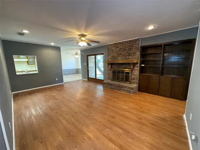 a view of an empty room with a fireplace and a window