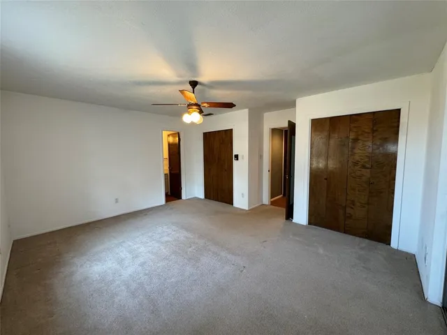 an empty room with chandelier fan